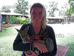 Simy and the baby kangaroo, the accommodation of the farm in the background