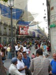 A lot of people everywhere, specialy during the summer sales period. In the background there is the advertisement of El Corte Inglés; up to 50% discount for clothes.